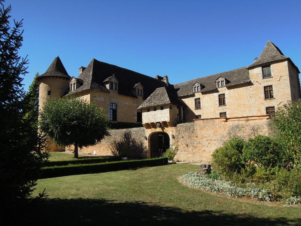 Chateau de Presque في Saint-Médard-de-Presque: مبنى حجري كبير امامه شجرة