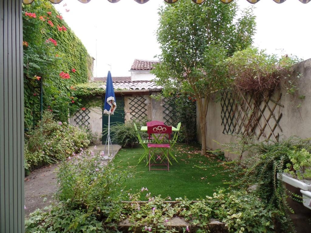 a garden with a table and a chair in it at Gite chez Cyrano in Bergerac