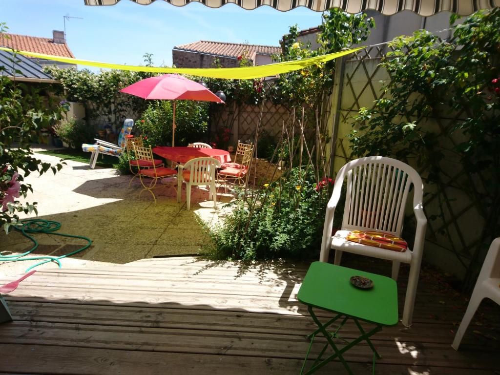 a patio with a table and chairs and an umbrella at Maison De Village in Barbechat