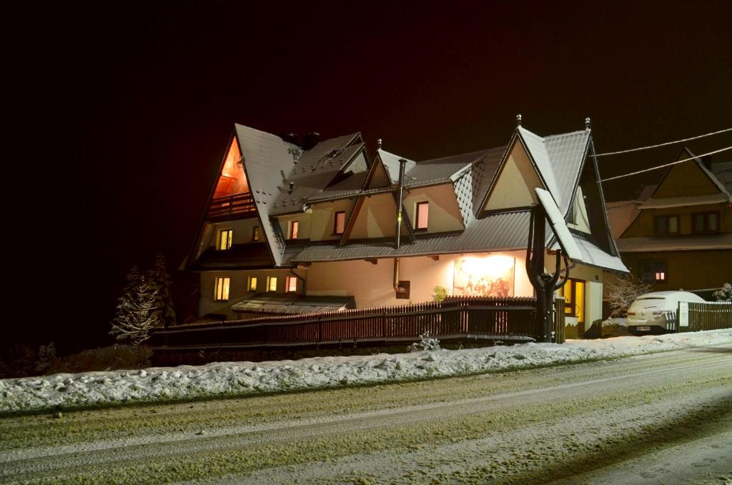 a large house on the side of a road at night at Gościniec Odsapka in Murzasichle