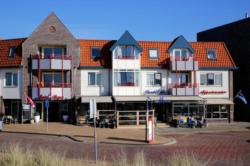 un grand bâtiment blanc avec des toits rouges dans l'établissement Hotel Meyer, à Bergen aan Zee