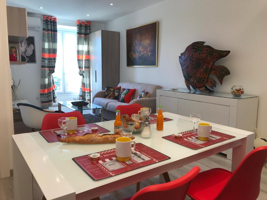 een woonkamer met een tafel en rode stoelen bij Candille in Nice