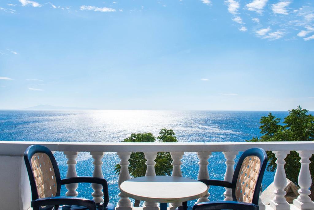 einen Tisch und Stühle auf einem Balkon mit Meerblick in der Unterkunft Marisini Sea View in Batsi