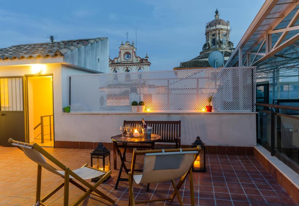 patio con mesa y sillas en el balcón en Apartamentos Turísticos Duque de Hornachuelos en Córdoba