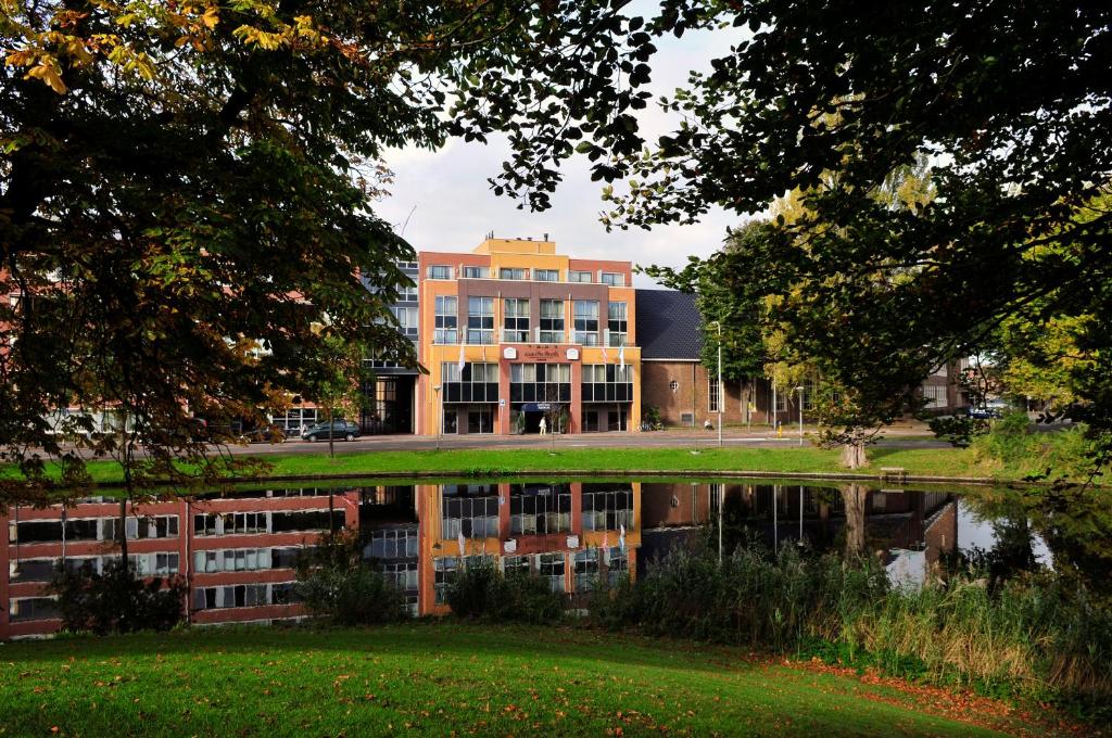 a building is reflected in a body of water at Amrâth Hotel Alkmaar in Alkmaar