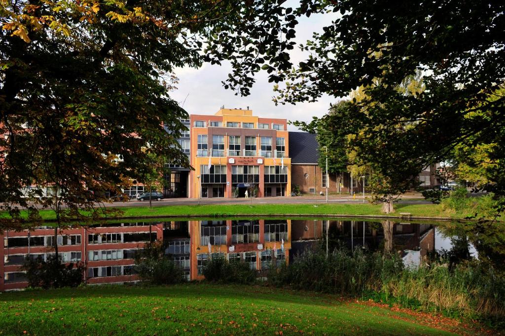 um edifício é refletido em uma massa de água em Amrâth Hotel Alkmaar em Alkmaar