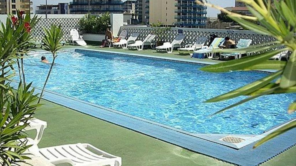 a large swimming pool with lounge chairs in a building at Gib city center in Gibraltar