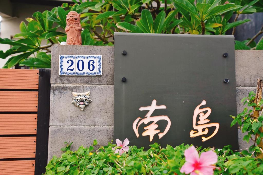 um sinal com um gato na parede com flores em South Island 206 em Hengchun Old Town