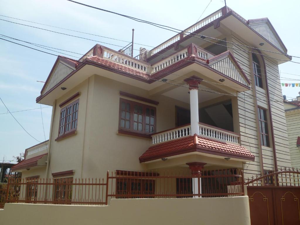 a house with a balcony on top of it at SUBI Home Stay in Kathmandu