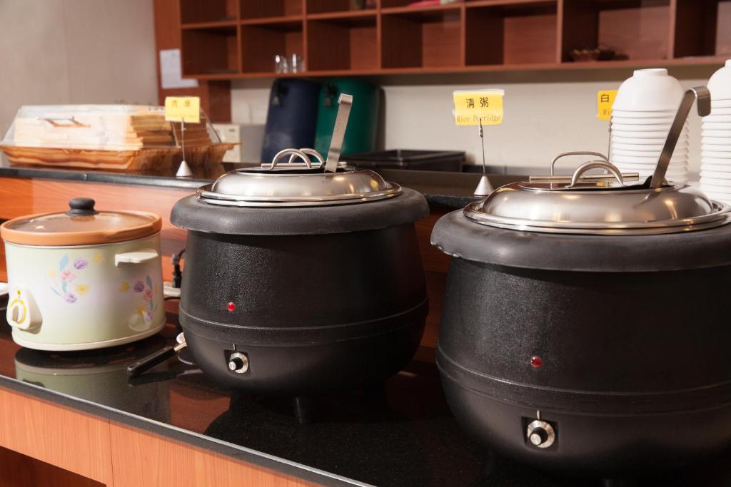 three pots and pans sitting on a counter in a kitchen at F Hotel - Chiayi in Fanlu