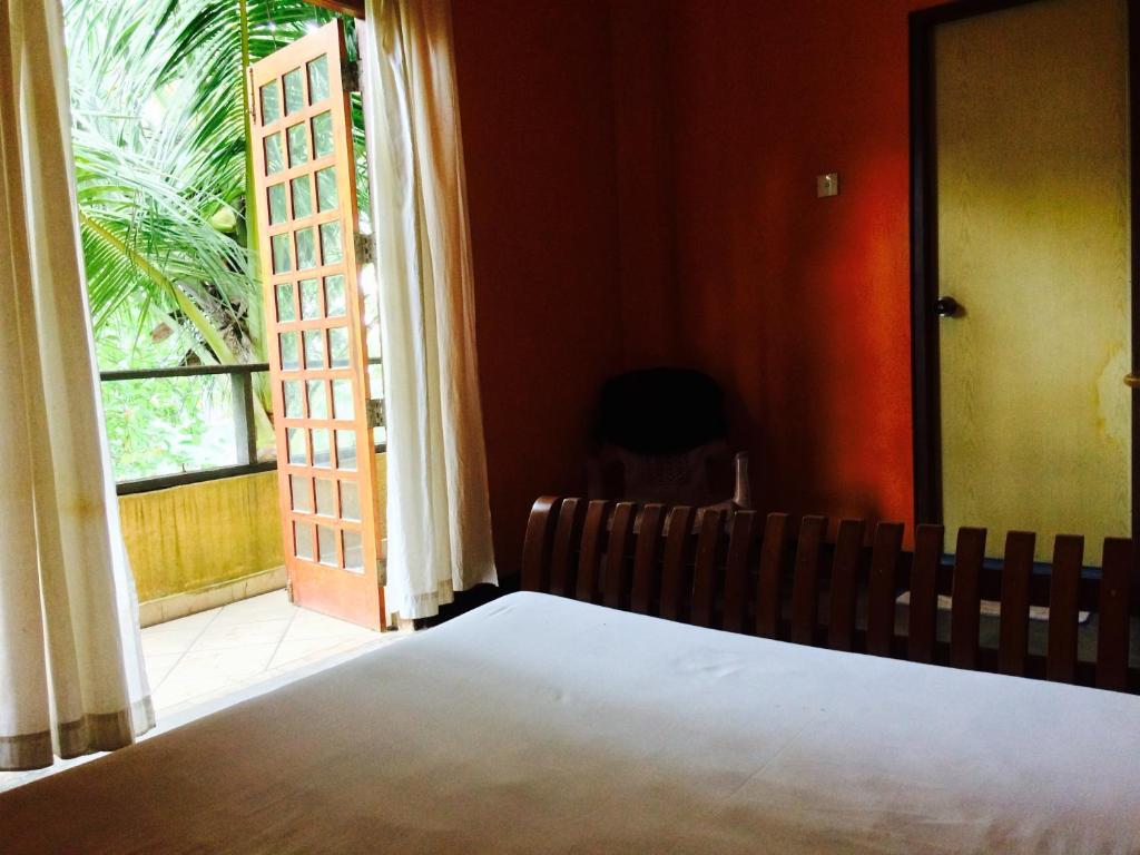 a bedroom with a bed and a large window at Reef Edge in Matara