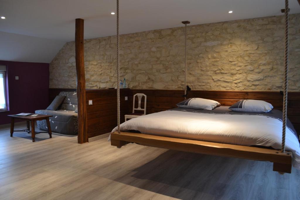 1 dormitorio con cama colgante y bañera en La Fauconnière, en Brécy