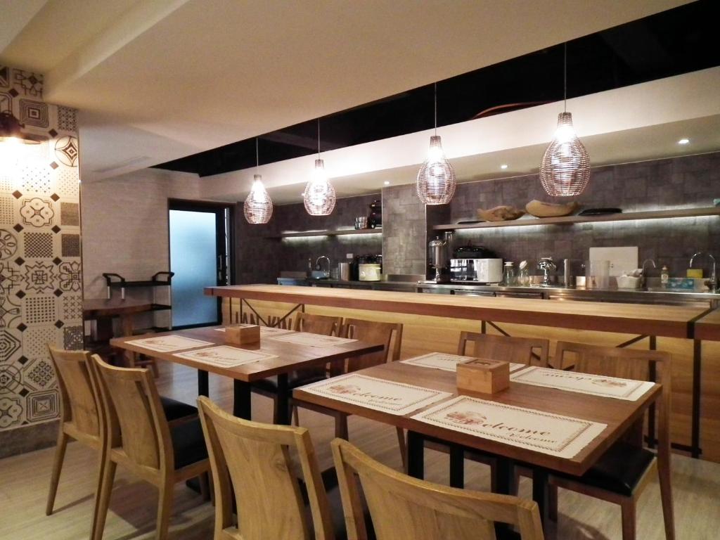 a restaurant with wooden tables and a kitchen at Lan Kwai Fong Garden Hotel in Chiayi City