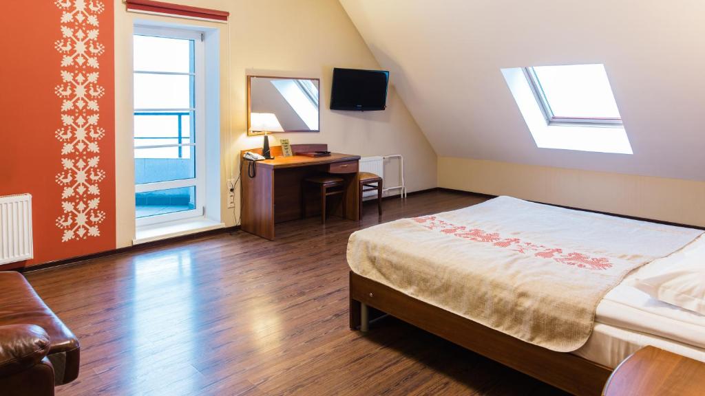 - une chambre avec un lit, un bureau et une fenêtre dans l'établissement Onega Castle Hotel, à Petrozavodsk