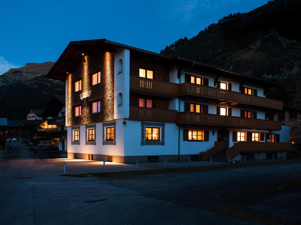 ein großes Gebäude mit vielen Fenstern in der Nacht in der Unterkunft Pension Kilian in Lech am Arlberg