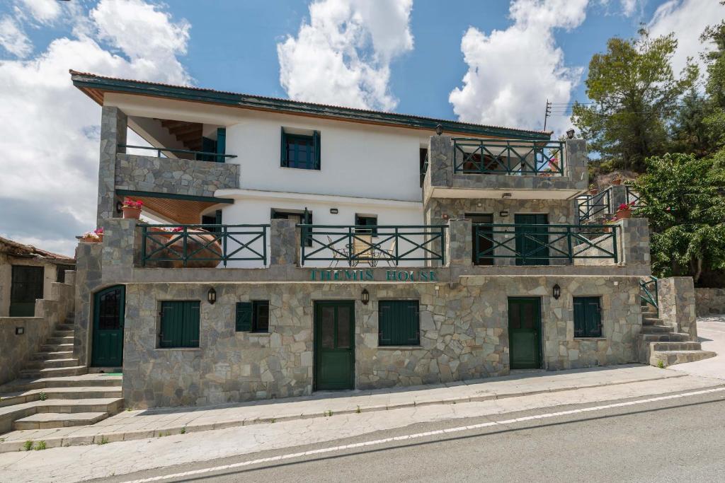 - un bâtiment en pierre avec un balcon au-dessus dans l'établissement Themis House, à Lemithou