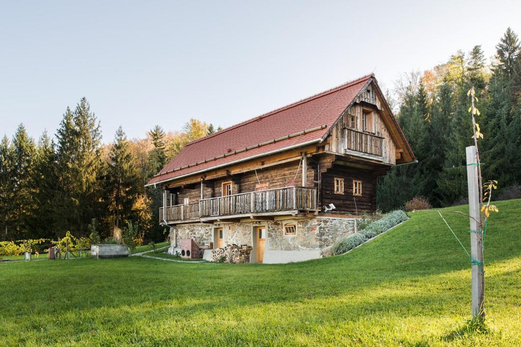 a large wooden house on a green field at Landhaus Moser in Leutschach