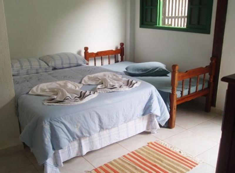a bedroom with two twin beds and a rug at Hospedagem dos Arvoredos in Ubatuba