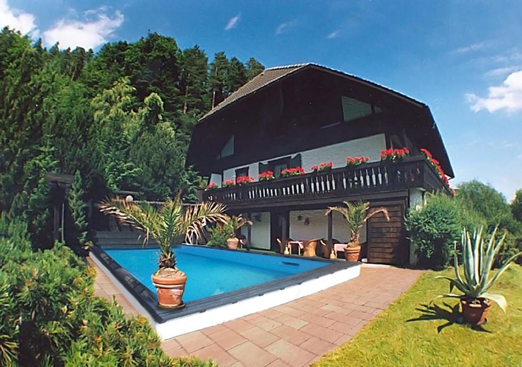 una casa con piscina en el patio en Appartementhaus Schwarzwaldblick, en Lauterbach