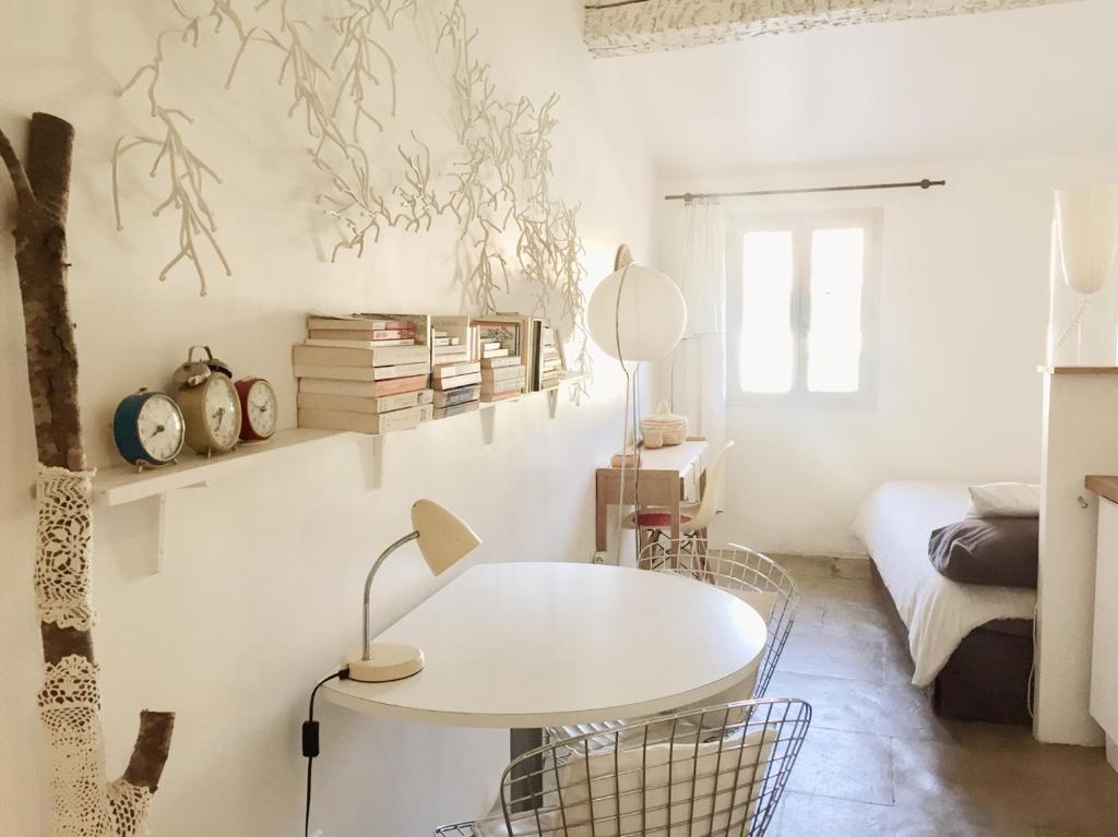 Cette chambre blanche dispose d'une table et d'un lit. dans l'établissement Mon Refuge Urbain, à Montpellier