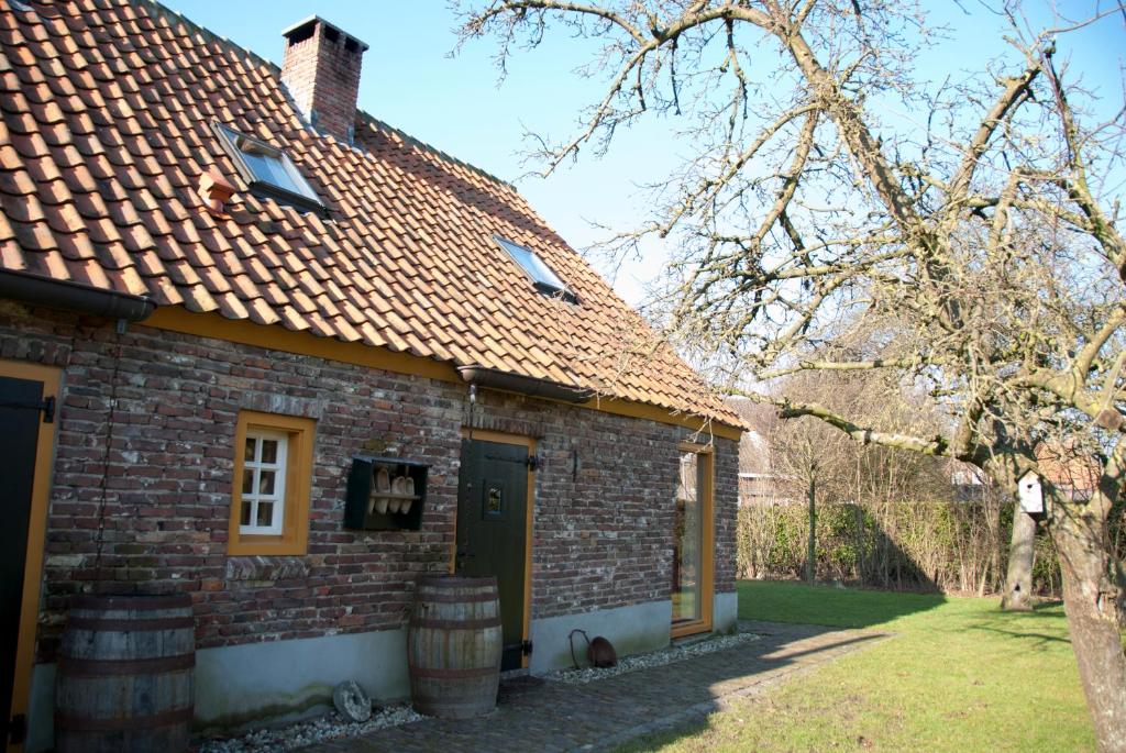 una vieja casa de ladrillo con una puerta verde en Cultuurlogies Looeind en Liempde