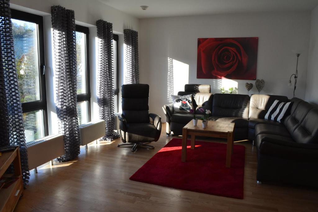 een woonkamer met een bank, stoelen en een tafel bij Ferienwohnung Sonnenkamp in Schmallenberg