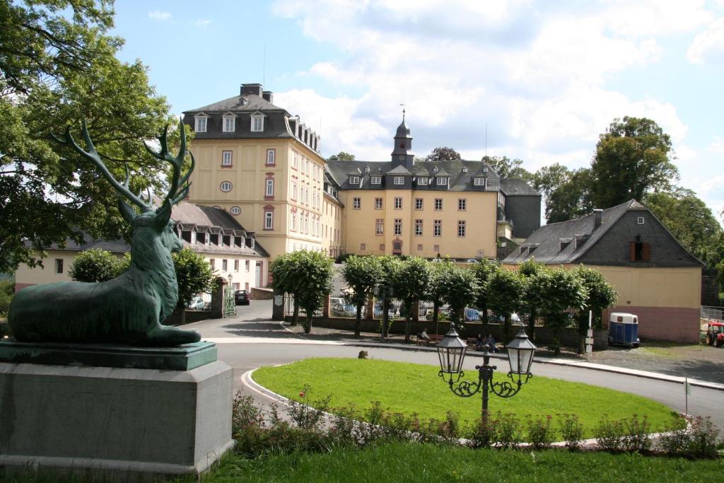 a statue of a deer in a park in front of a building at Schloß Wittgenstein in Bad Laasphe
