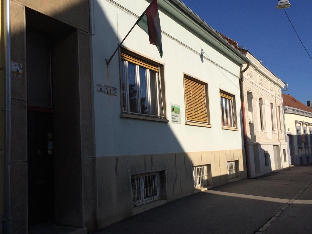 ペーチにあるKolpingház Pécsの旗の横の建物