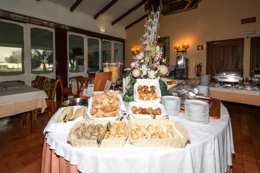 a table with several baskets of bread on it at Hotel Apartamento Do Golfe in Vilamoura