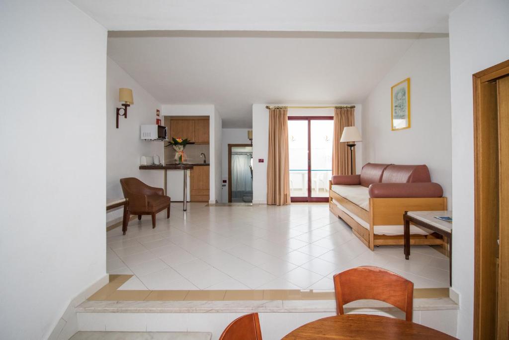 a living room with a couch and a table at Hotel Apartamento Do Golfe in Vilamoura