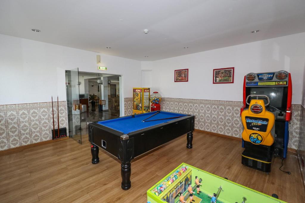 a room with a pool table and a arcade game at Hotel Apartamento Do Golfe in Vilamoura