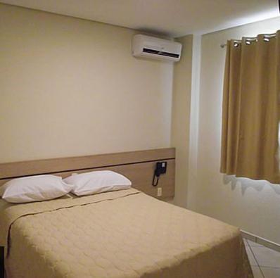 a bedroom with a bed with two pillows at Hotel Eden in Sorocaba