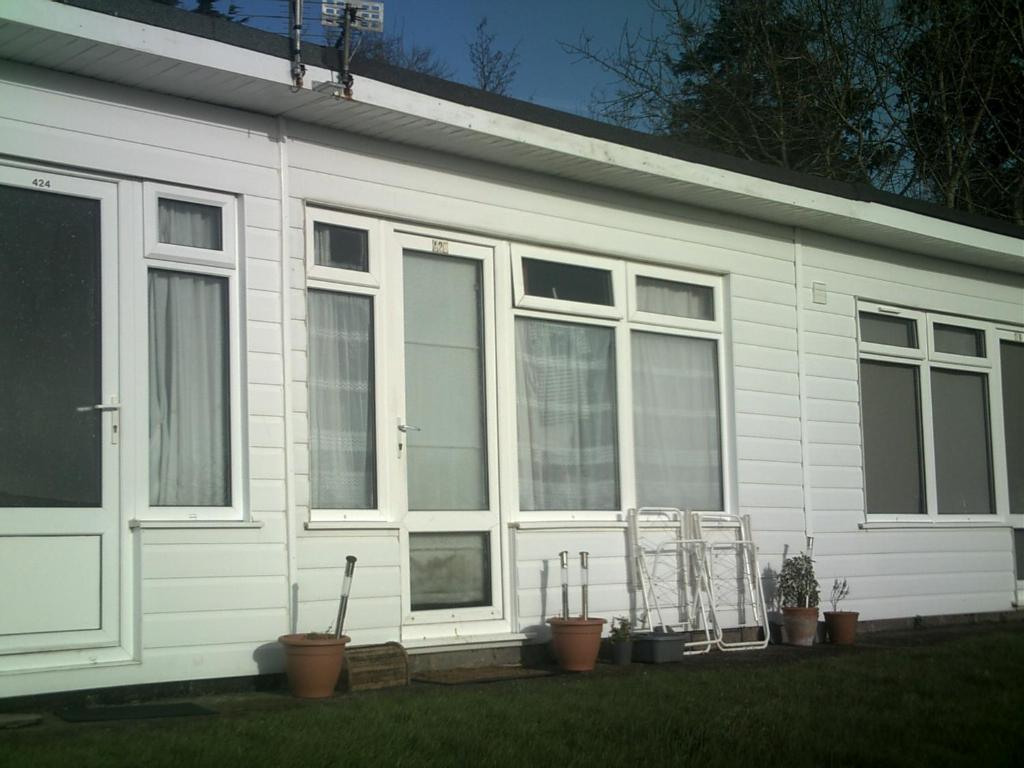 a white house with windows and potted plants at Adventure Cabin in Dartmouth