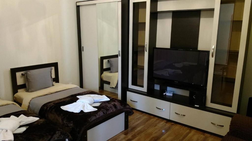 una habitación de hotel con dos camas y un televisor de pantalla plana en Apartment Avlabari (In old Tbilisi), en Tiflis