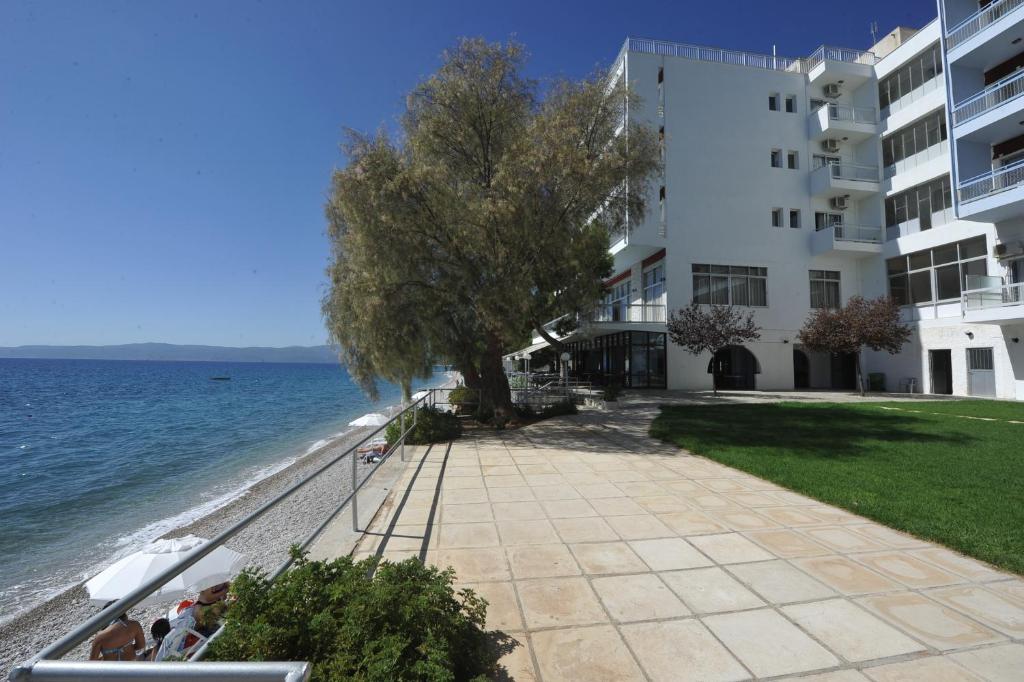 a building on the beach next to the water at Siagas Beach Hotel in Agioi Theodoroi