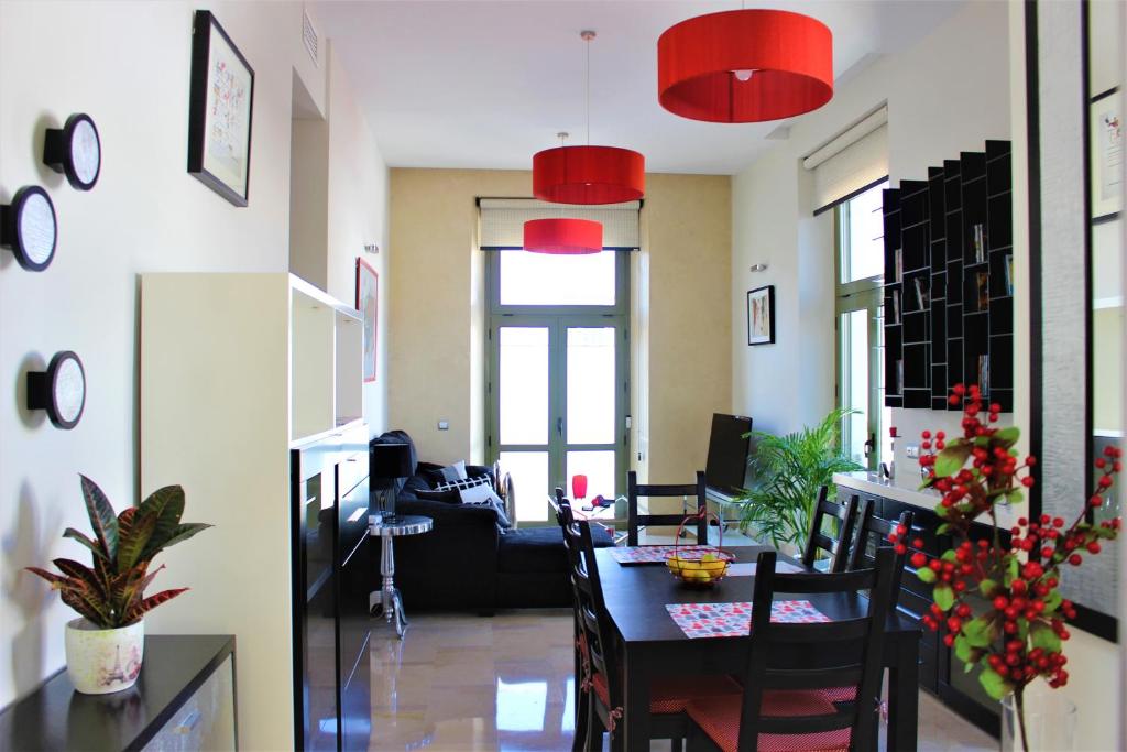 an office with a table and chairs and red lamps at Luxury Apartment Sierpes in Seville