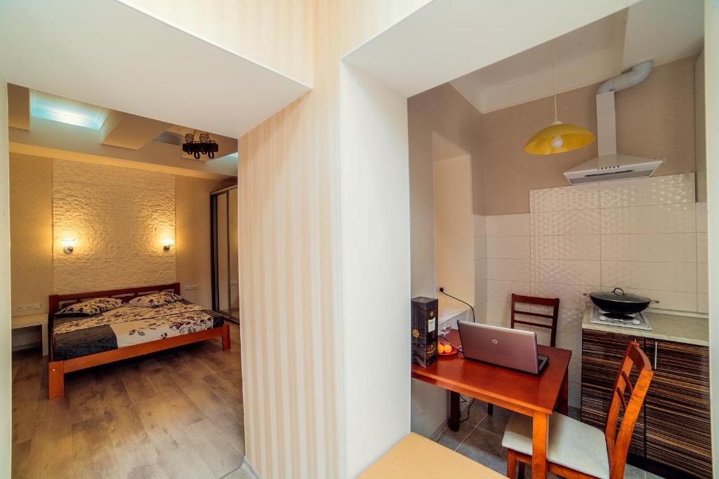 a bedroom with a bed and a desk with a laptop at Студия рядом с Горсадом in Odesa