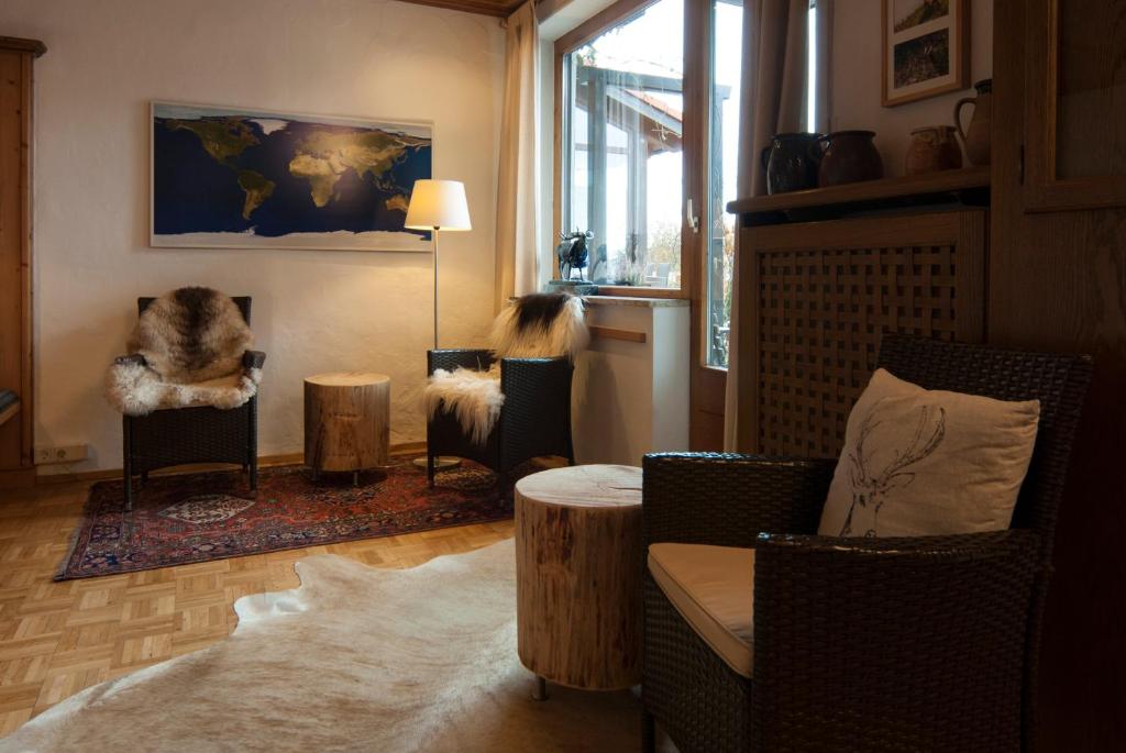Alpenlodge Pfronten في بفرونتن: غرفة معيشة مع كراسي وأريكة وطاولة