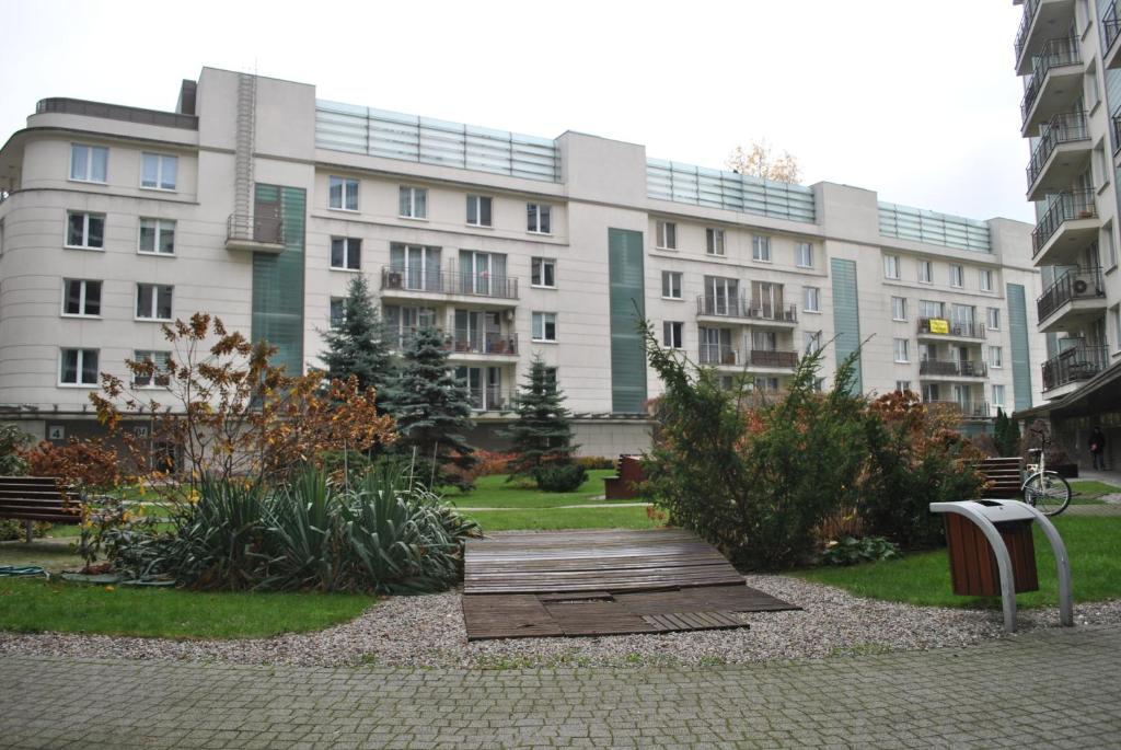 ワルシャワにあるŻoliborz Apartamentyの公園前のベンチ付き建物