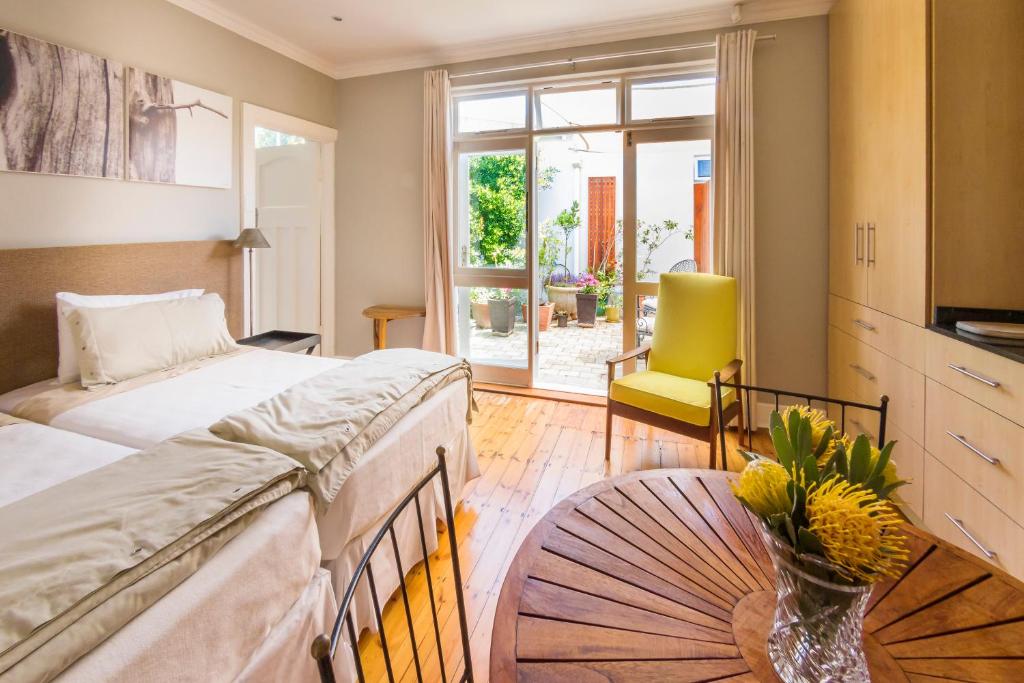伊麗莎白港的住宿－B's Place，一间卧室设有两张床和一张花瓶桌子。