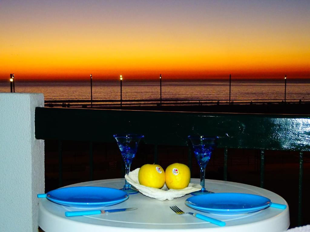 a table with a plate of fruit on a table near the beach at Apartment Vasco da Gama in Costa da Caparica