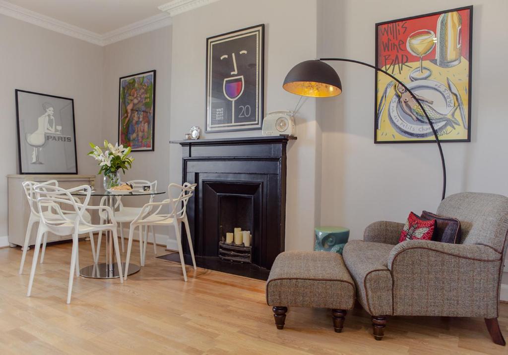 een woonkamer met een open haard en een tafel en stoelen bij The Skyline - The Edinburgh Address in Edinburgh