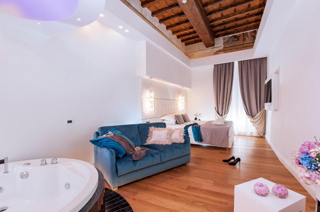 uma sala de estar com um sofá azul e uma banheira em Argentina Residenza Style Hotel em Roma