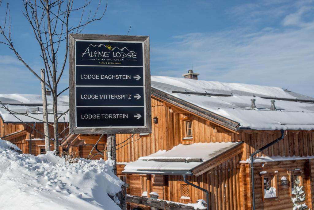 ein Schild vor einer Lodge im Schnee in der Unterkunft Alpine-Lodge in Schladming