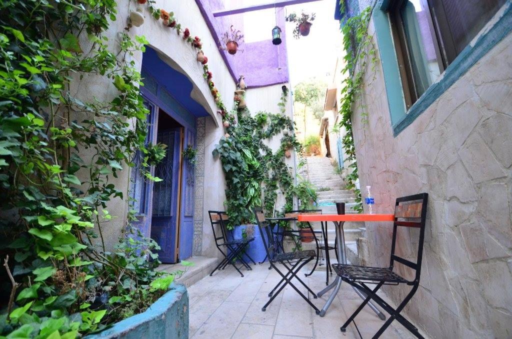 eine Terrasse mit einem Tisch und Stühlen in einer Gasse in der Unterkunft Zaman Ya Zaman Boutique Hotel in Amman