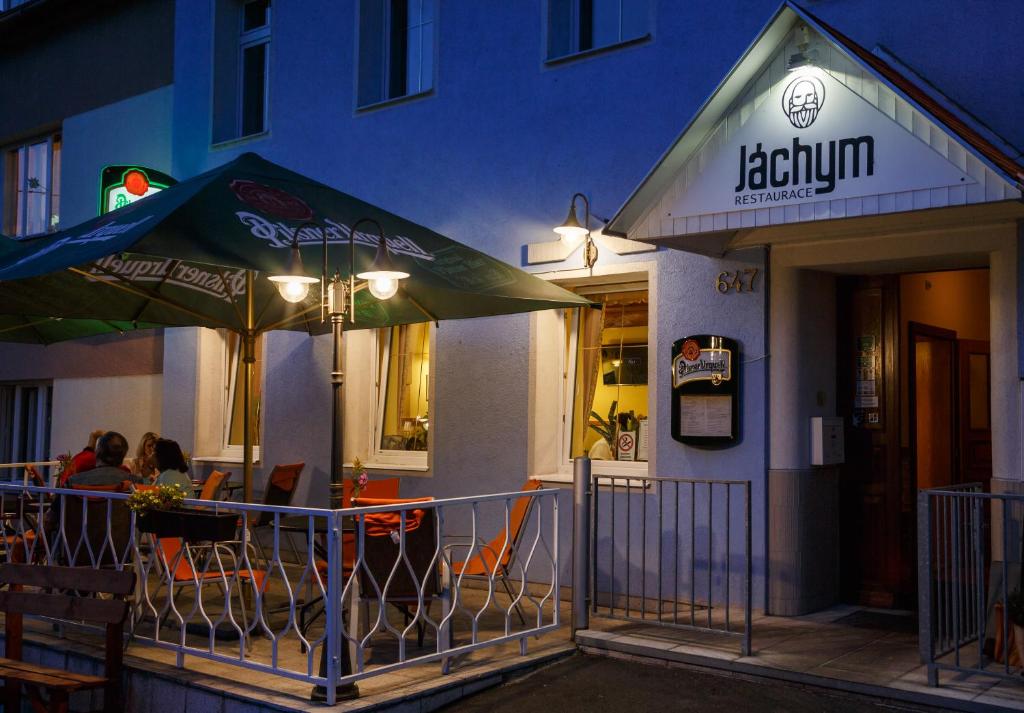 a restaurant with two umbrellas in front of a building at Hotel Orix in Jáchymov