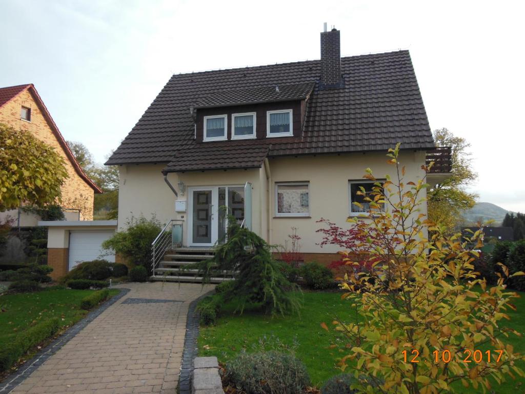 ein kleines weißes Haus mit einer steinernen Einfahrt in der Unterkunft Ferienwohnung E.F. Schaper in Stadtoldendorf