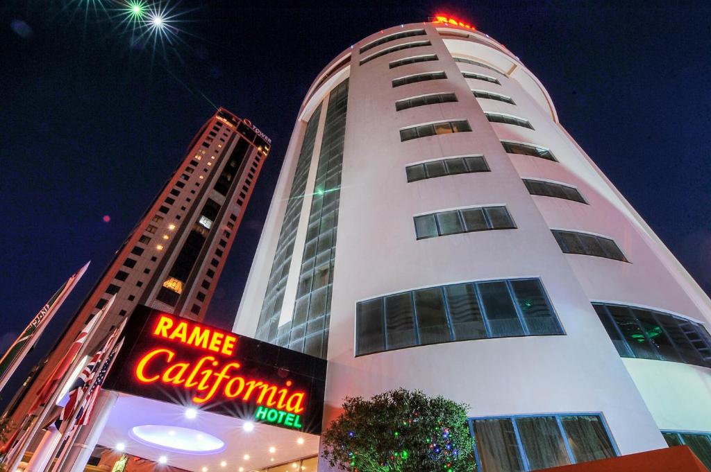 فندق رامي كاليفورنيا في المنامة: مبنى أبيض طويل مع علامة أمامه
