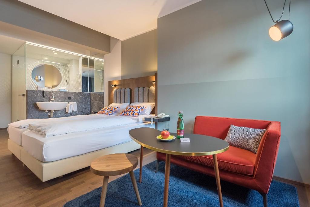 een slaapkamer met een bed, een tafel en een stoel bij Hotel Ploberger in Wels