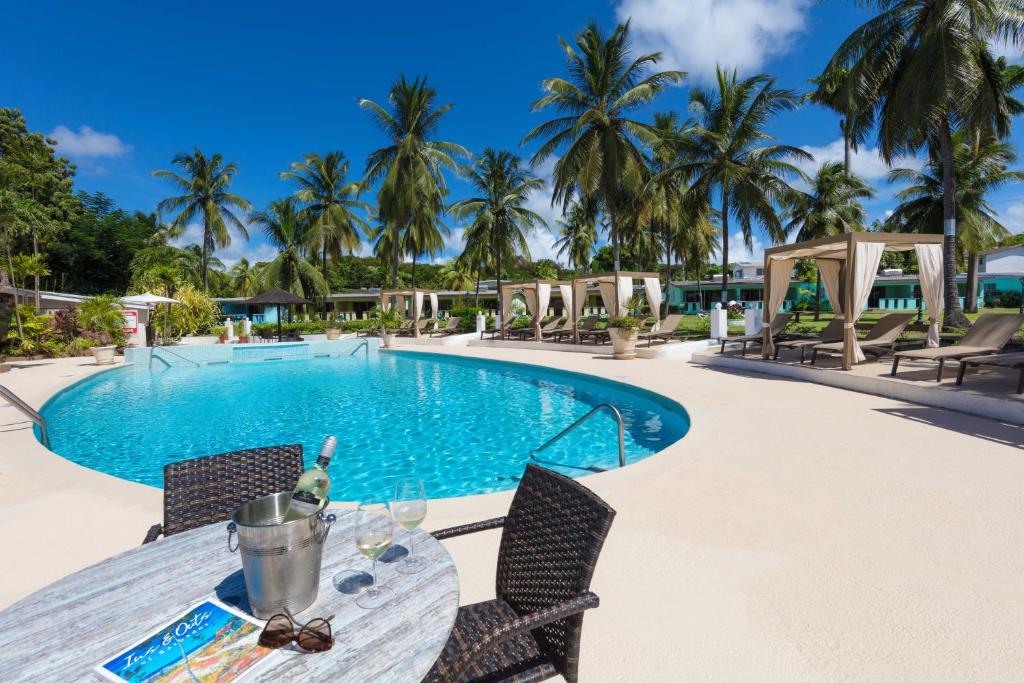 a pool with chairs and tables in it at All Seasons Resort in Saint James